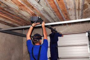 Rechnicians fixing a broken garage door